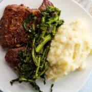 Garlic mashed potato with steak and broccoli rabe.