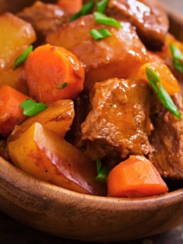 Brown bowl full of meat and vegetable pieces.