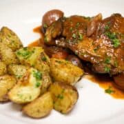 Chicken braised in red wine, or chicken broth, or juices, such as unsweetened tart cherry, cranberry or pomegranate juice.