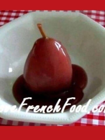 Piece of fruit covered in red sauce in white bowl on red and white cloth.