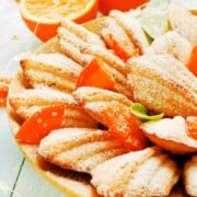 Leaf shaped cake cookies sprinkled with icing sugar and bits of dried orange peel.