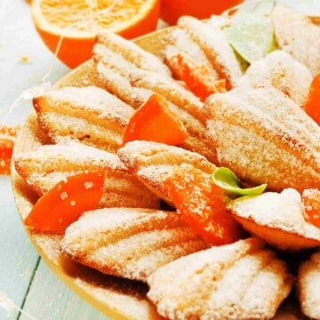 Leaf shaped cake cookies sprinkled with icing sugar and bits of dried orange peel.