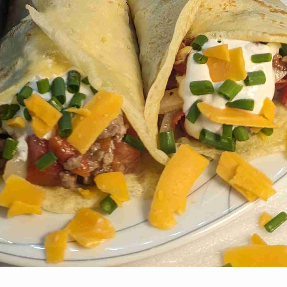 Two crepes stuffed with meat and vegetables.