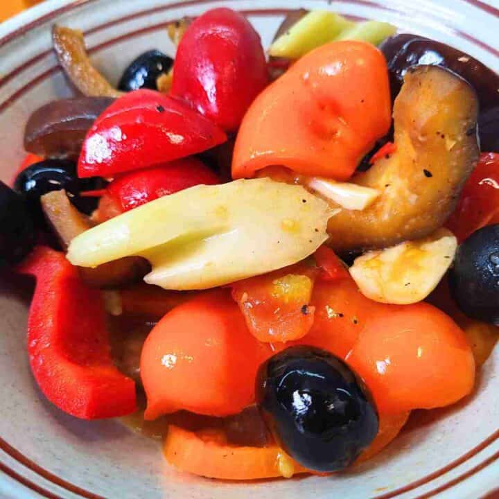 A bowl of cooked, ready to eat colorful vegetable stew.