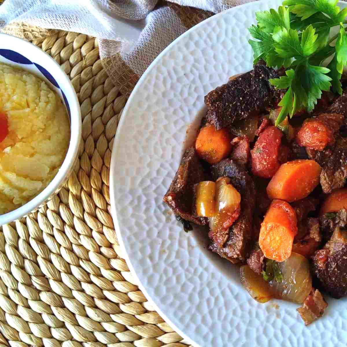 French cooked beef stew called Daube de Boeuf with colorful vegetables and polenta on the side.