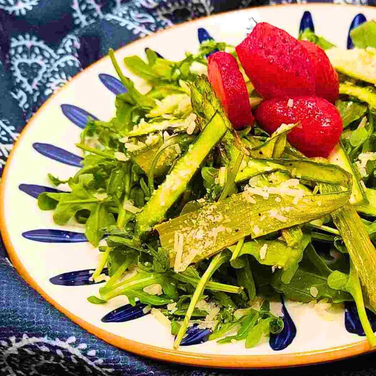Arugula salad simply made with asparagus ribbons, parmesan and lemon salad dressing.