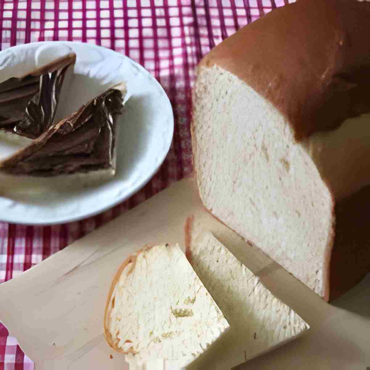 A loaf of French brioche bread sliced and ready to eat with chocolate spread.