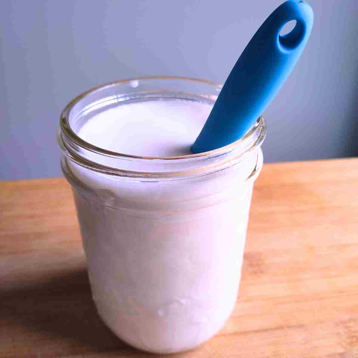 Cultured Buttermilk and heavy cream being stirred in the jar.