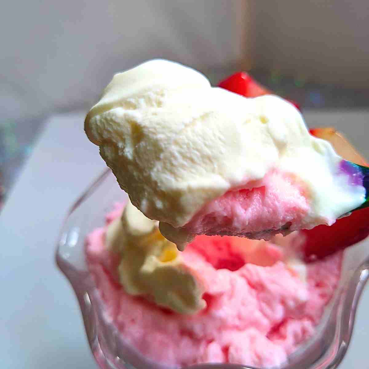 A spoonful of strawberry mousse topped with creme fraiche.