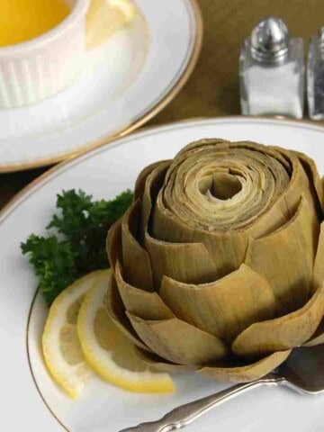 Steamed artichoke trimmed, with lemon and melted butter.