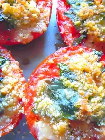 Photo of quick and easy oven roasted tomatoes sprinkled with herbs and cheese.