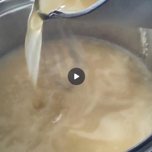 Adding warm stock slowly to the roux limits lumps from developing.