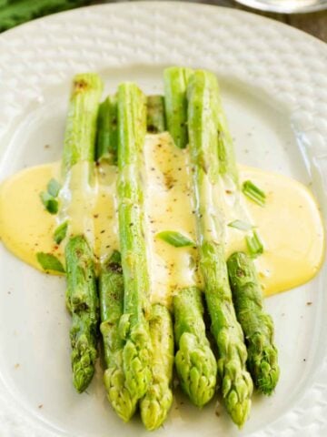 Spears of green asparagus covered in delicious hollandaise sauce.