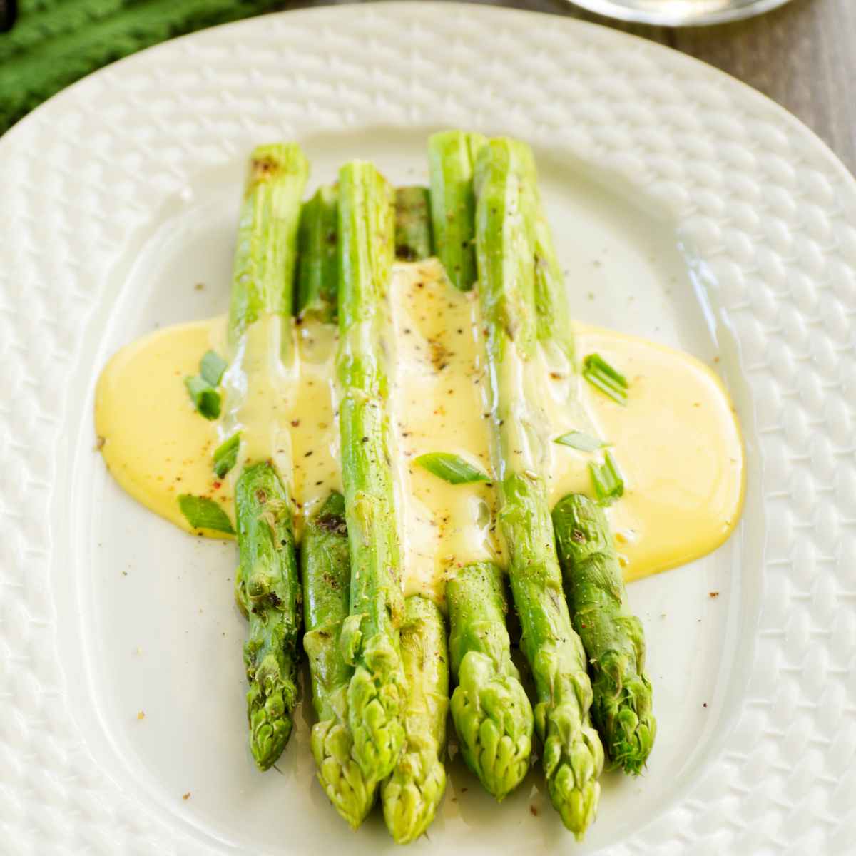 Spears of green asparagus covered in delicious hollandaise sauce.