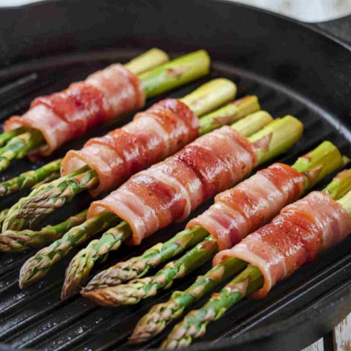 Asparagus wrapped in bacon, grilled in a skillet until cooked perfectly.