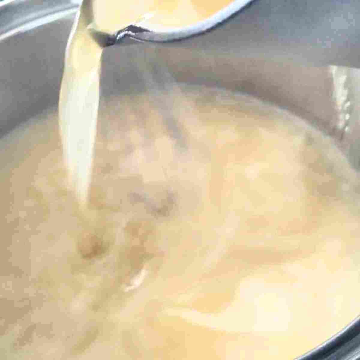 Adding warm stock slowly to the roux limits lumps from developing.