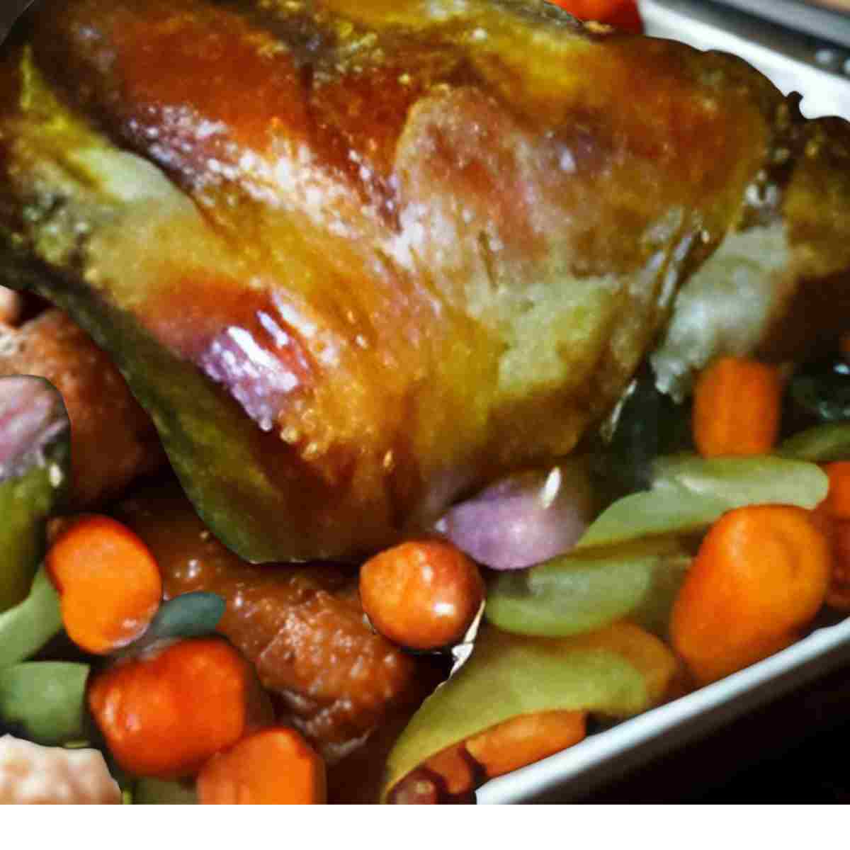 Roaster pan filled with golden leg of lamb and colorful veggies.