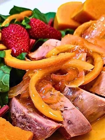 A delicious duck l'orange dinner with sliced orange peel in the luscious sauce on duck meat.