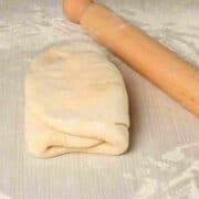 A step in making puff pastry where the dough is folded over the butter.
