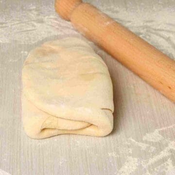 A step in making puff pastry where the dough is folded over the butter.