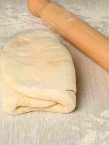 A step in making puff pastry where the dough is folded over the butter.