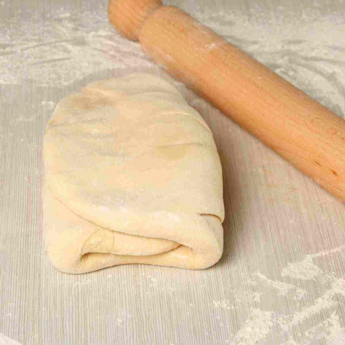 A step in making puff pastry where the dough is folded over the butter.