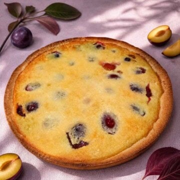 Plum tart is a classic French dessert of fruit custard filling baked in a short crust pastry.