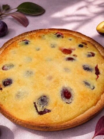 Plum tart is a classic French dessert of fruit custard filling baked in a short crust pastry.