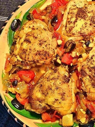 Chicken cooked in wine, tomatoes, black olives, aubergine, and herbs.
