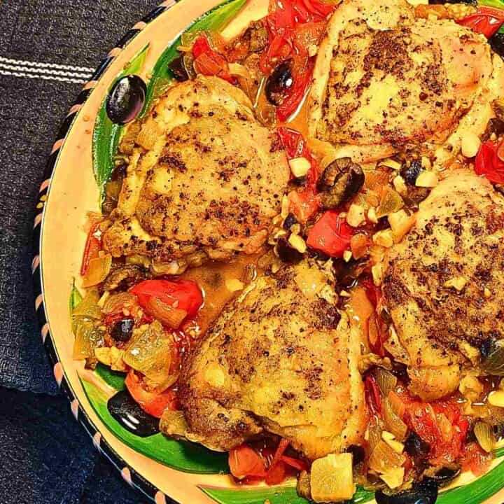Chicken cooked in wine, tomatoes, black olives, aubergine, and herbs.