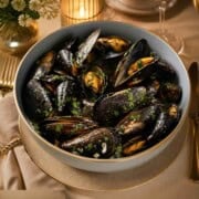 Mussels cooked in a buttery, lemon wine sauce with onions, parsley, and shallots