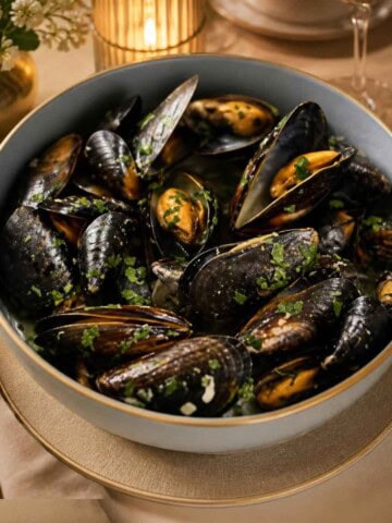 Mussels cooked in a buttery, lemon wine sauce with onions, parsley, and shallots
